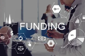 Image of a businessman reviewing documents, overlaid with financial icons and graphs. The word 'FUNDING' is prominently displayed, suggesting a focus on financial analysis or investment.