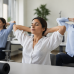 Práctica de Yoga Estilismo Laboral session with an office professional doing gentle desk yoga for posture, focus, and daily energy